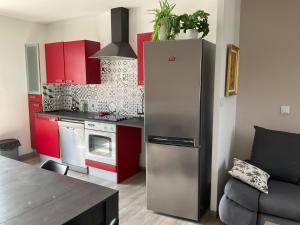 a kitchen with a stainless steel refrigerator and red cabinets at Marco Christophe Regine in Saturargues