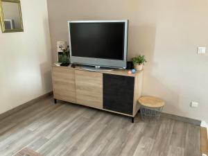 a flat screen tv sitting on top of a wooden cabinet at Marco Christophe Regine in Saturargues