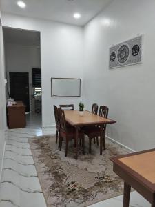 a dining room with a wooden table and chairs at Seri Desa Homestay in Kuala Terengganu
