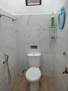 a bathroom with a toilet and a phone on the wall at Seri Desa Homestay in Kuala Terengganu