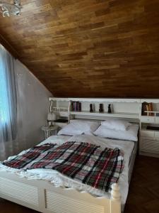 una camera da letto con un letto con soffitto in legno di Somlyay’s Summer House a Balatonalmádi Altre 28 foto