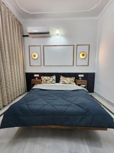 a bedroom with a large bed with a blue blanket at Owee Stays - A stay with more stories in Jaipur