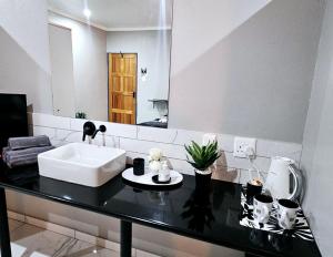 un baño con lavabo y espejo en LoopLê, en Klerksdorp 63 fotos más