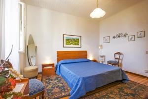 a bedroom with a bed with a blue comforter at Piazzale Italia in Oggebbio