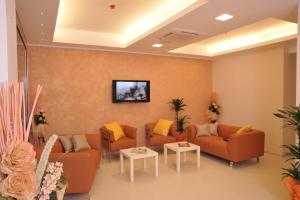 a waiting room with couches and a tv on a wall at Residence Perla in Misano Adriatico