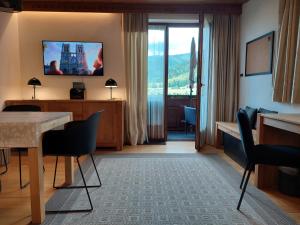 a hotel room with a table and a television on the wall at Apartment am Wolfgangsee in Strobl