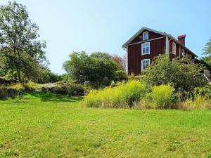 een rood huis op een heuvel met een grasveld bij Idyllic Family Retreat Close to the Sea in Ronneby
