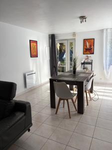 a living room with a black table and chairs at Location de vacances brocéliandes in Maxent