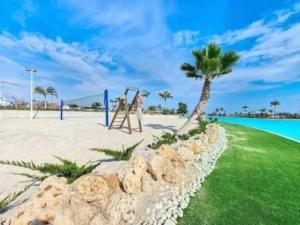 a man is playing on a swing on the beach at Casa Emerald by Rental Hero in Torre-Pacheco