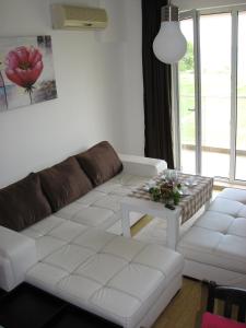 Una sala de estar con un sofá blanco y una mesa. en Two-Bedroom Apartment Donika, en Tsarevo