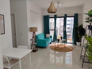 a living room with a blue couch and a table at AquaPrivate 1Bhk Apartment in Amanora Park Town in Pune