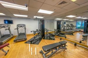 a gym with treadmills and elliptical machines at LUX - The Downtown Blvd Suite in Dubai