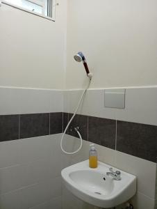 a bathroom with a sink and a blow dryer on the wall at A&Z Homestay Kangar with 4 Bedroom 3 Bathroom in Kangar