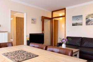 a living room with a table and a couch at MEI27a Ferienwohnung Ostseetraum in Niendorf