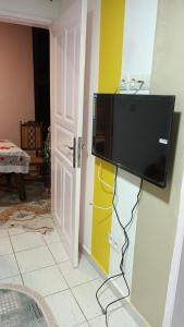 a flat screen tv hanging on a wall in a room at La myrtille de Liesse in Nzamata