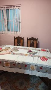 a table with a quilt on it with two chairs at La myrtille de Liesse in Nzamata