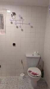 a bathroom with a toilet with flowers on the wall at La myrtille de Liesse in Nzamata