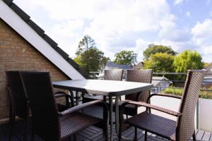 a patio table and chairs on a balcony at MEI27a Ferienwohnung Ostseetraum in Niendorf