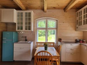 a kitchen with a table and a blue refrigerator at Brzozowisko in Brzozówka