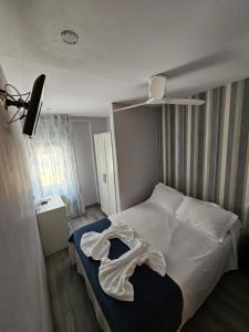 a bedroom with a bed with a white blanket on it at HOSTAL FONCALADA in Oviedo