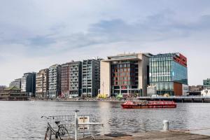 a red boat in the water in front of buildings at Neptune Boatique Hotel Amsterdam in Amsterdam
