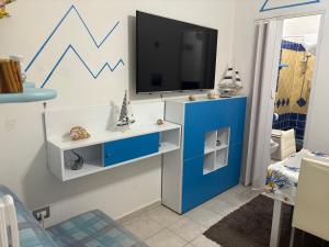 a living room with a tv and a blue cabinet at La Stanza del Mare in Calasetta