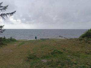a bench sitting on the beach near the water at 5 person holiday home in Tarm in Tarm