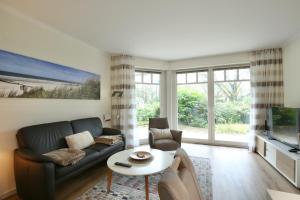 a living room with a couch and a table at Wohnung Aurora im Haus Nautilus in Wangerooge