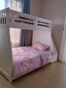 a white bunk bed with pink sheets and a pillow at The Viewpoint - Kigo in Kigo