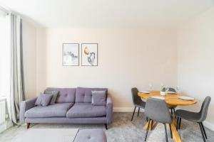Una sala de estar con un sofá morado y una mesa. en Ascot Racecourse Apartment - Free Parking, en Ascot