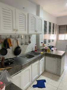 a kitchen with white cabinets and a sink at Happy hostel in Casablanca