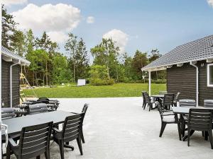 a group of tables and chairs on a patio at 5 star holiday home in Frederiksværk in Frederiksværk