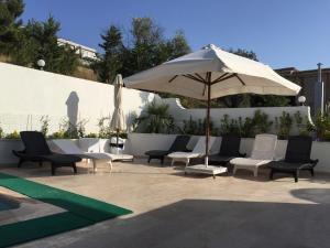 a group of chairs and an umbrella on a patio at Cicek Apart Hotel in Cesme