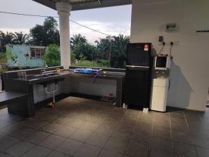 a kitchen with a desk and a sink and a window at Embun Lodg in Temerloh