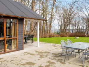 un patio con tavolo e sedie e un campo di Cozy Retreat in Lojtland - By Traum Ferienwohnungen a Aabenraa