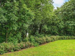 un giardino con prato, alberi e cespugli di Cozy Retreat in Lojtland - By Traum Ferienwohnungen a Aabenraa