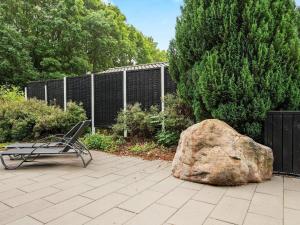 una panchina e una grande roccia accanto a una recinzione di Cozy Retreat in Lojtland - By Traum Ferienwohnungen a Aabenraa