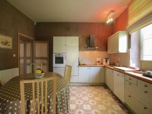 eine Küche mit einem Tisch und weißen Schränken in der Unterkunft Rustic Charm, Modern Comfort in Latour