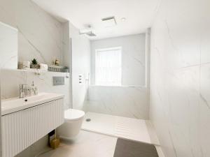 a white bathroom with a toilet and a sink at Serene Home ideally connected to Central London in Bickley +23 photos