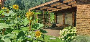 a garden with sunflowers and a house with a patio at Sauna2relax in Šveicarija