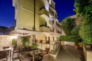 a patio with a table and chairs in front of a building at Hotel Alessandrino in Rome