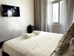 a bedroom with a bed with a tv on the wall at Dar EL BAHIA - Spacious flat with large Terrace in Casablanca