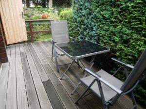una mesa y 2 sillas en una terraza de madera en Bungalow Brandl, en Zinnowitz