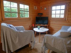 sala de estar con 2 sillas, mesa y TV en Bungalow Brandl, en Zinnowitz 10 fotos más