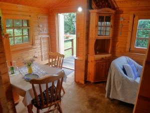 Un comedor con una mesa y un televisor en una cabaña. en Bungalow Brandl, en Zinnowitz