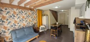 un salon avec un canapé bleu et une cuisine dans l'établissement Zéphyr, à Saint-Christol