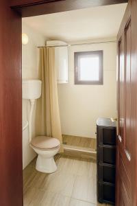 um banheiro com vaso sanitário e janela em Kuća iz zavičaja em Kuršumlija