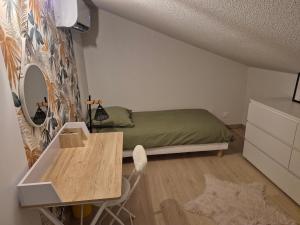 une petite chambre avec un lit et une table dans l'établissement Zéphyr, à Saint-Christol