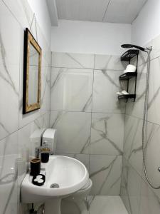 a white bathroom with a sink and a mirror at Matea Room in Himare