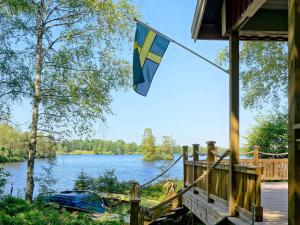 a flag on the side of a house with a lake at 8 person holiday home in Hyltebruk in Hyltebruk +23 photos
